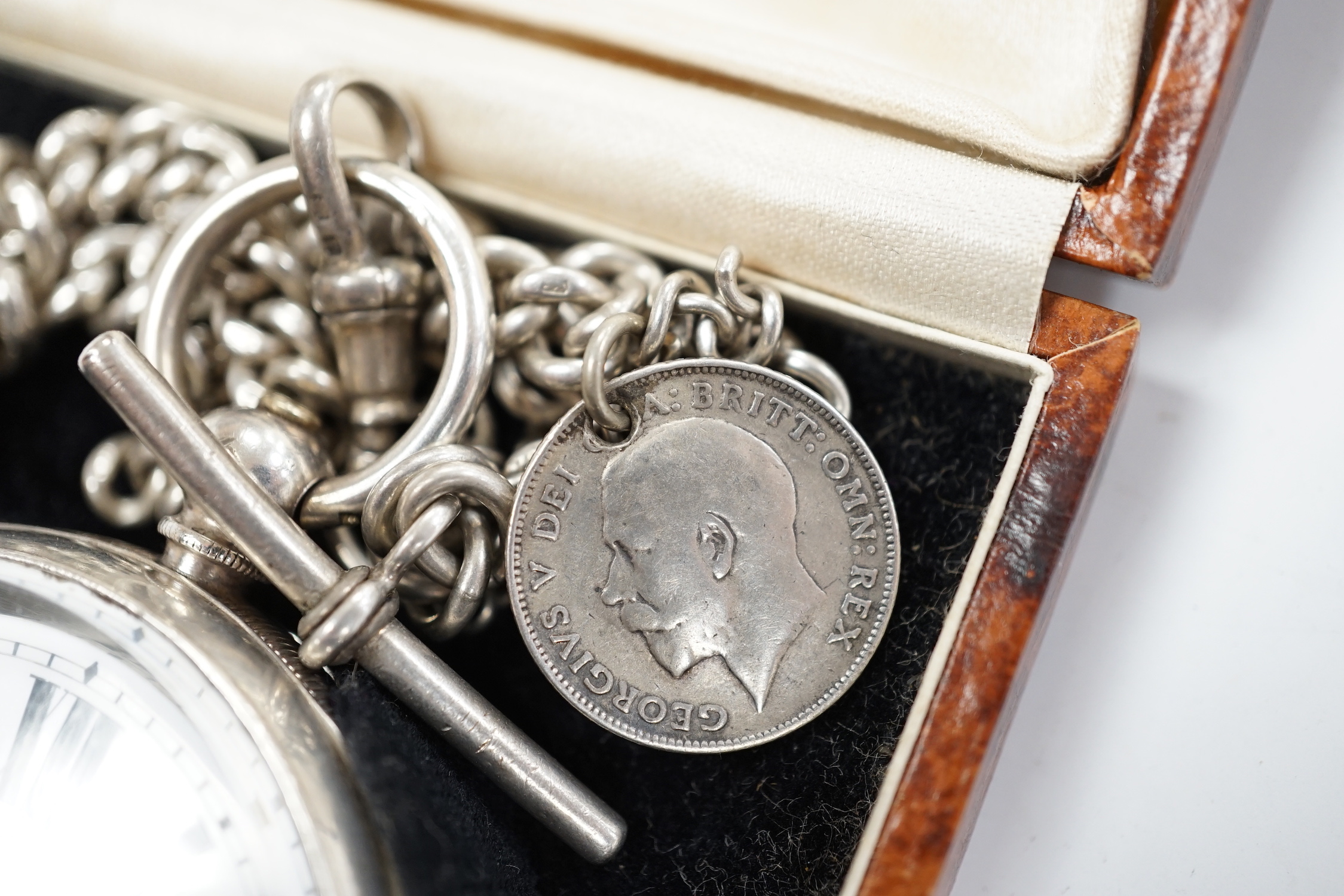 A Swiss 935 white metal open faces keyless pocket watch, with Roman dial and subsidiary second, on a silver albert.
